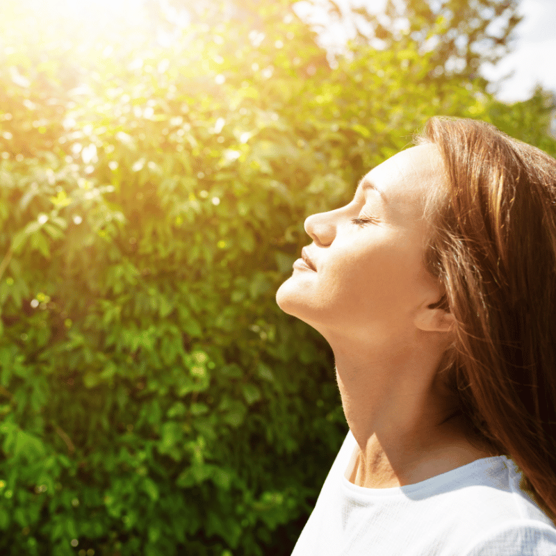 Breathe easy with SoyKitty, a 99% dust-free cat litter. Woman outside taking a deep breath