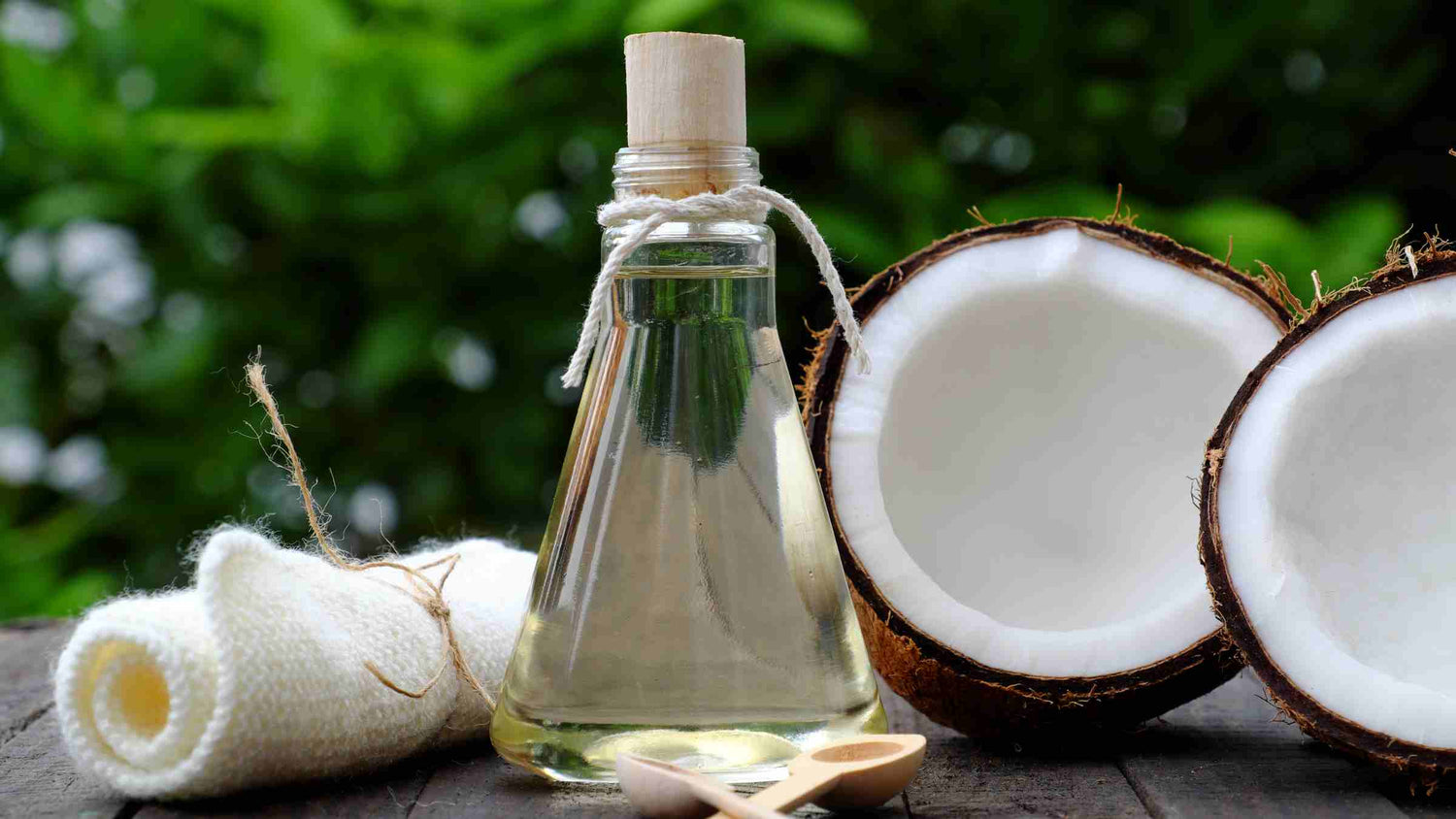 Coconut oil and essential oils for making a DIY natural cat salve for itchy skin, displayed with fresh coconut halves and a green natural backdrop