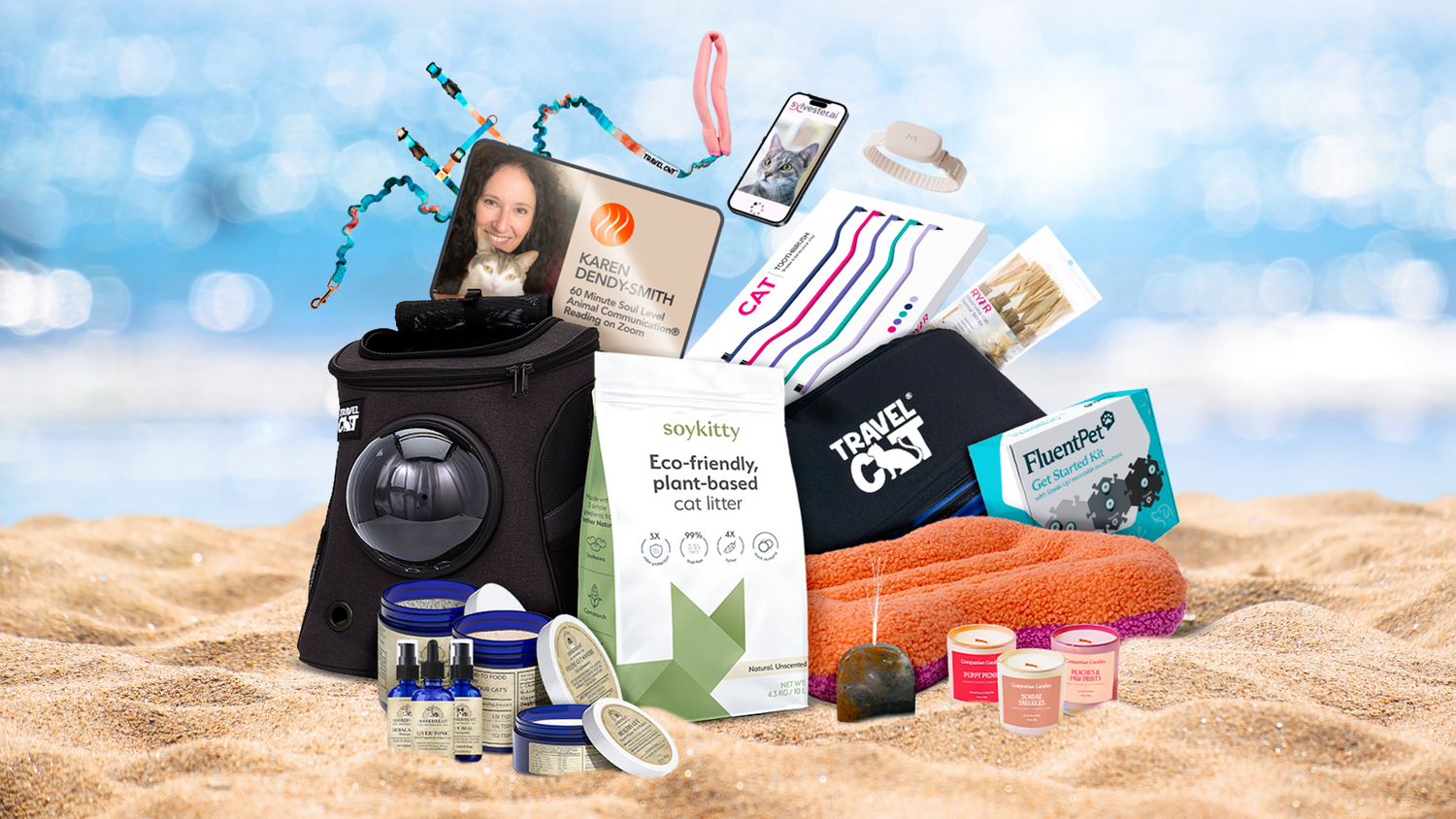 Giveaway prize bundle on sandy beach including SoyKitty eco-friendly plant-based cat litter and assorted cat care products from multiple participating brands.