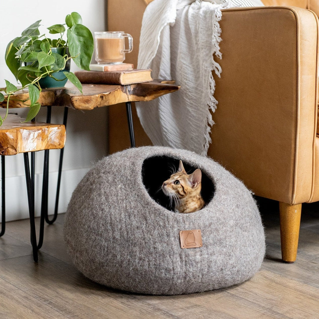 SoyKitty felted wool cat cave bed in Earth Brown with Bengal cat inside next to rustic wood furniture
