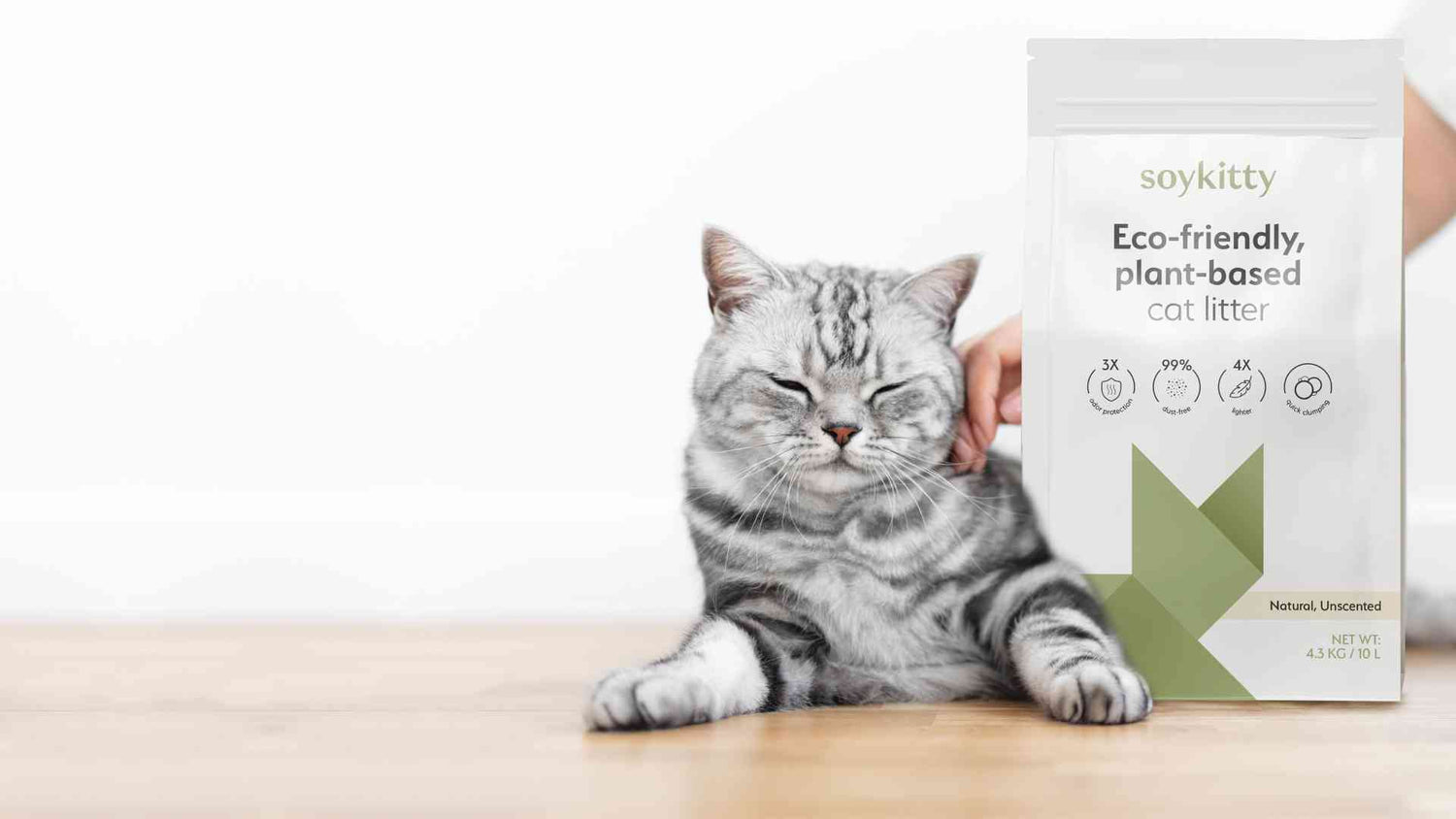 Grey tabby cat beside SoyKitty eco-friendly cat litter package, highlighting features like odor control, dust-free, lightweight, and high absorption, on a white background