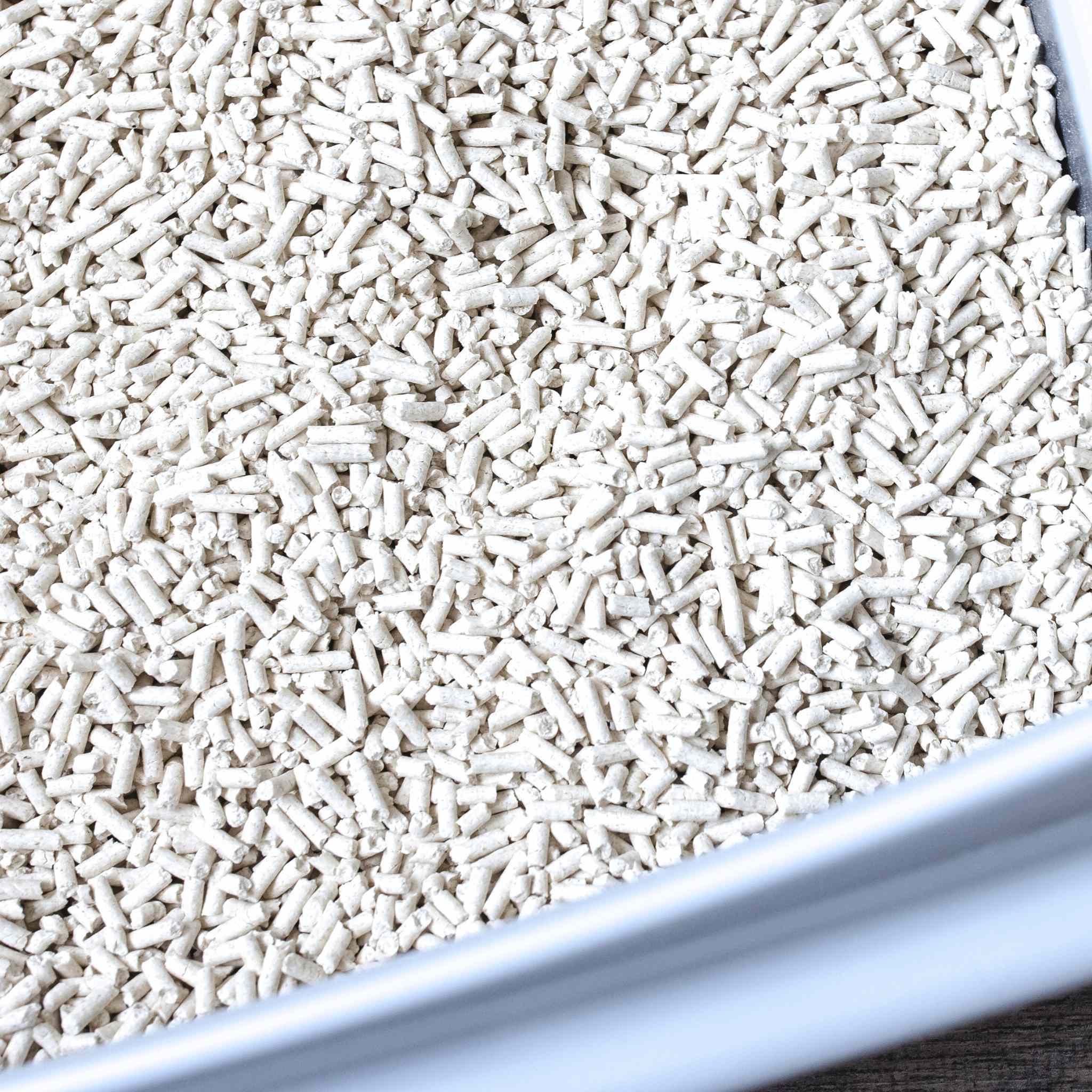 Close-up of tofu cat litter pellets in a litter box, highlighting the final eco-friendly product made from the soybeans