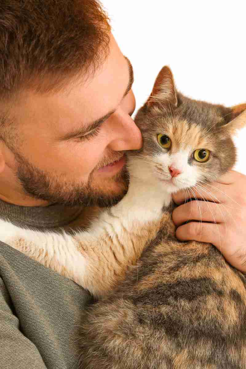 White man holding a cat. SoyKitty...cat litter made by cat people for cat people.